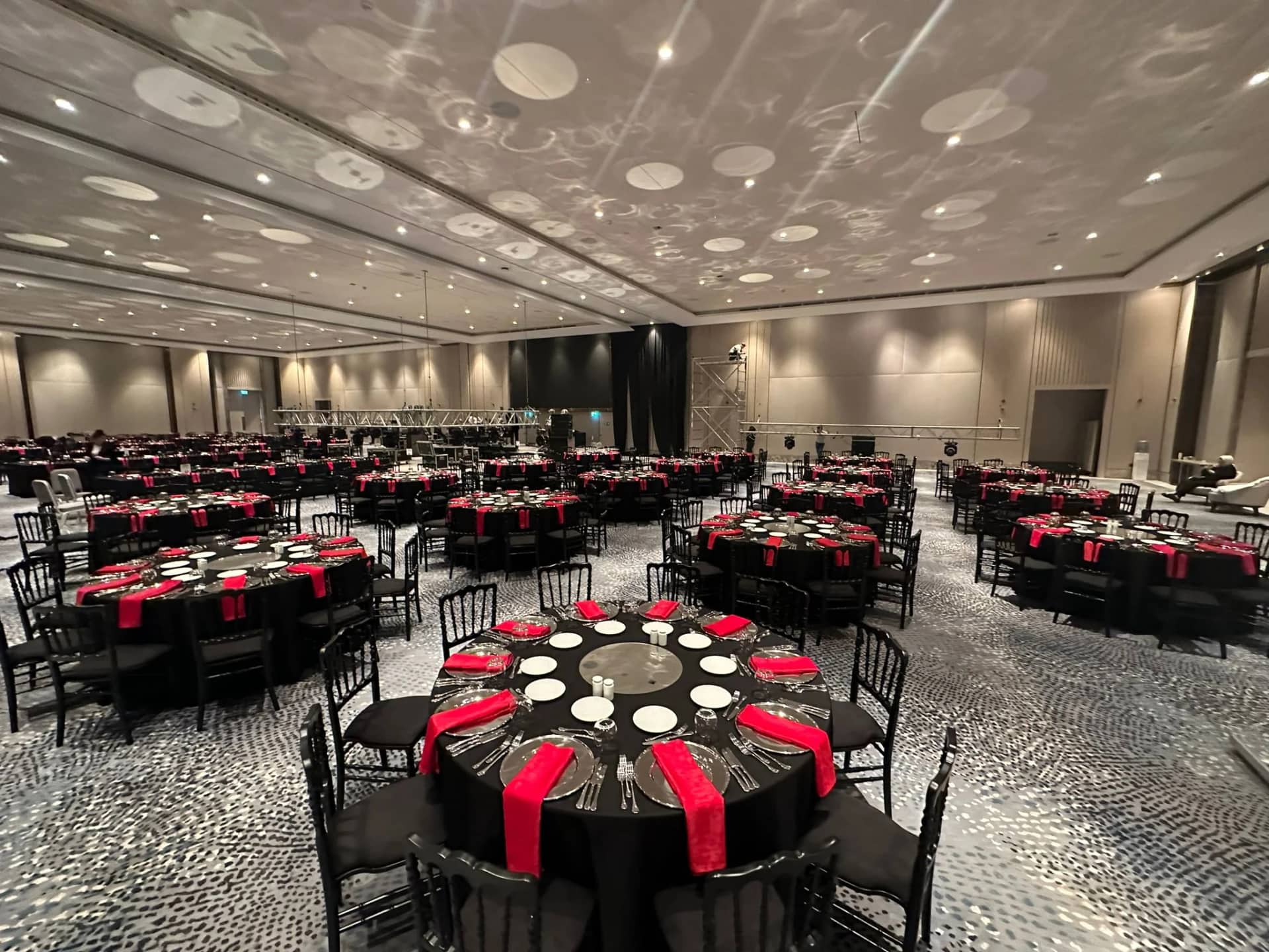 Round banquet tables with Napoleon chairs arranged for 100 guests