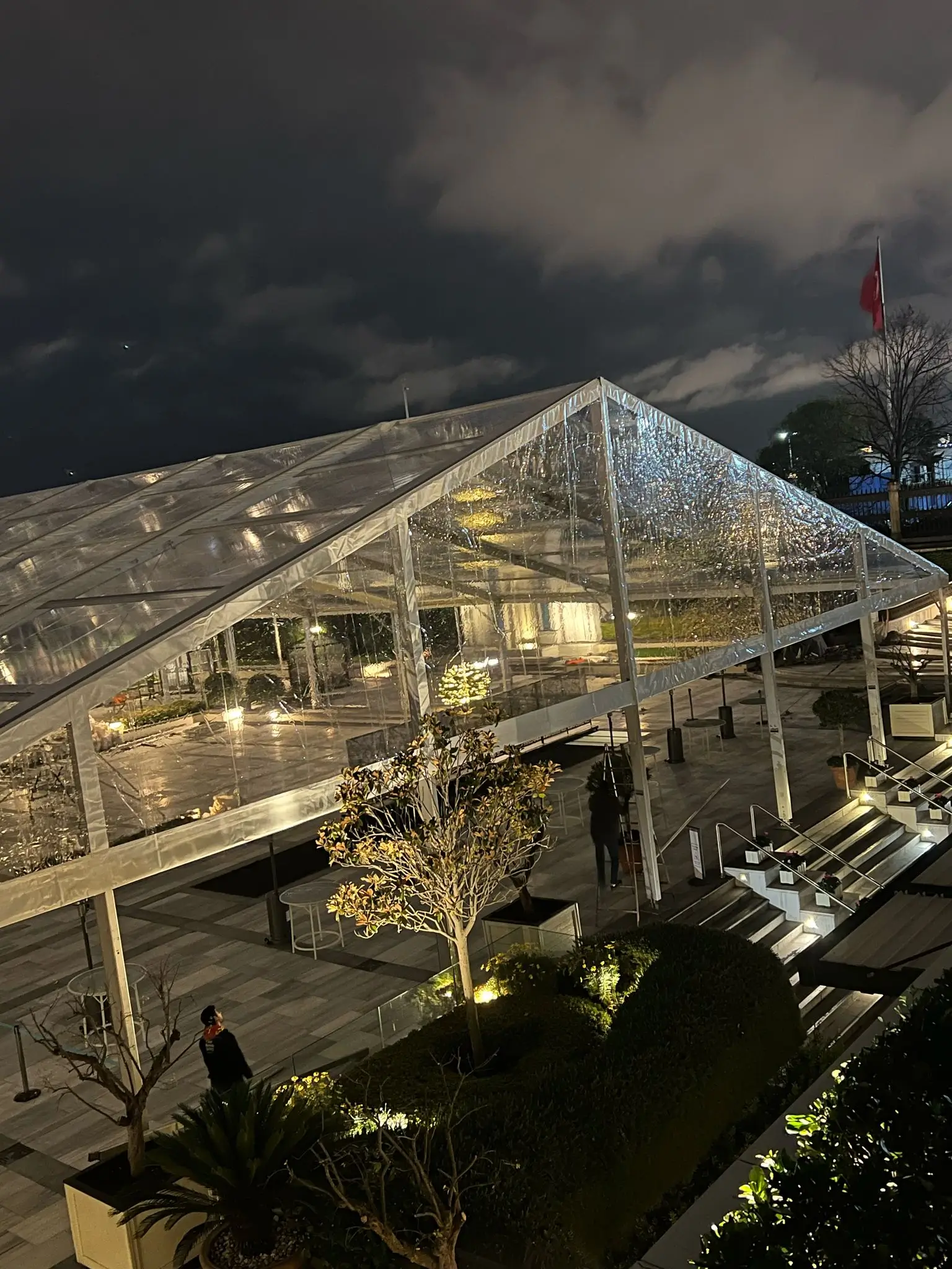 Gece aydınlatmalı şeffaf çadır kurulumu, otel bahçesinde davet alanı