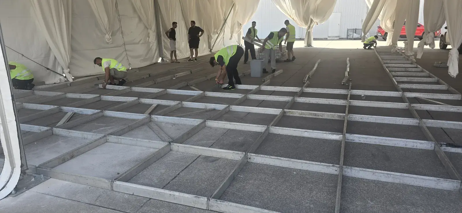 Sahneva ekibinin etkinlik çadırı içinde modüler podyum zemini kurması