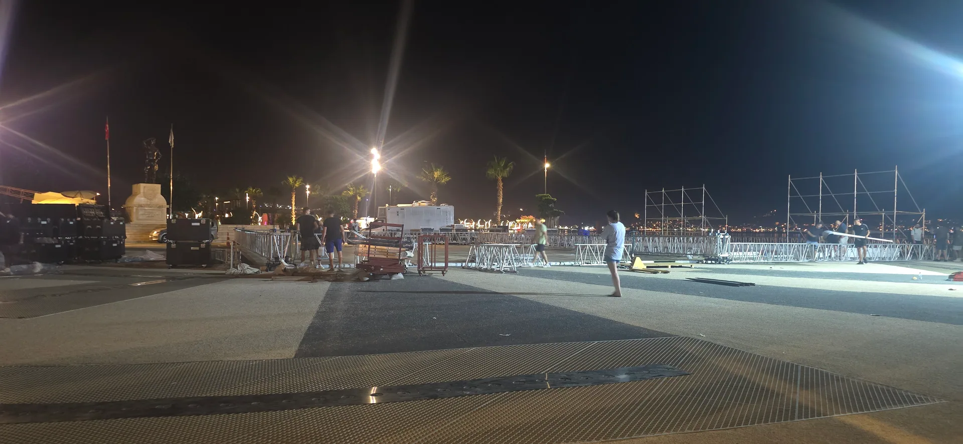 Fethiye lansman alanında gece çalışan kurulum ekibi, yerdeki alüminyum truss parçaları ve taşıyıcı çerçeveler